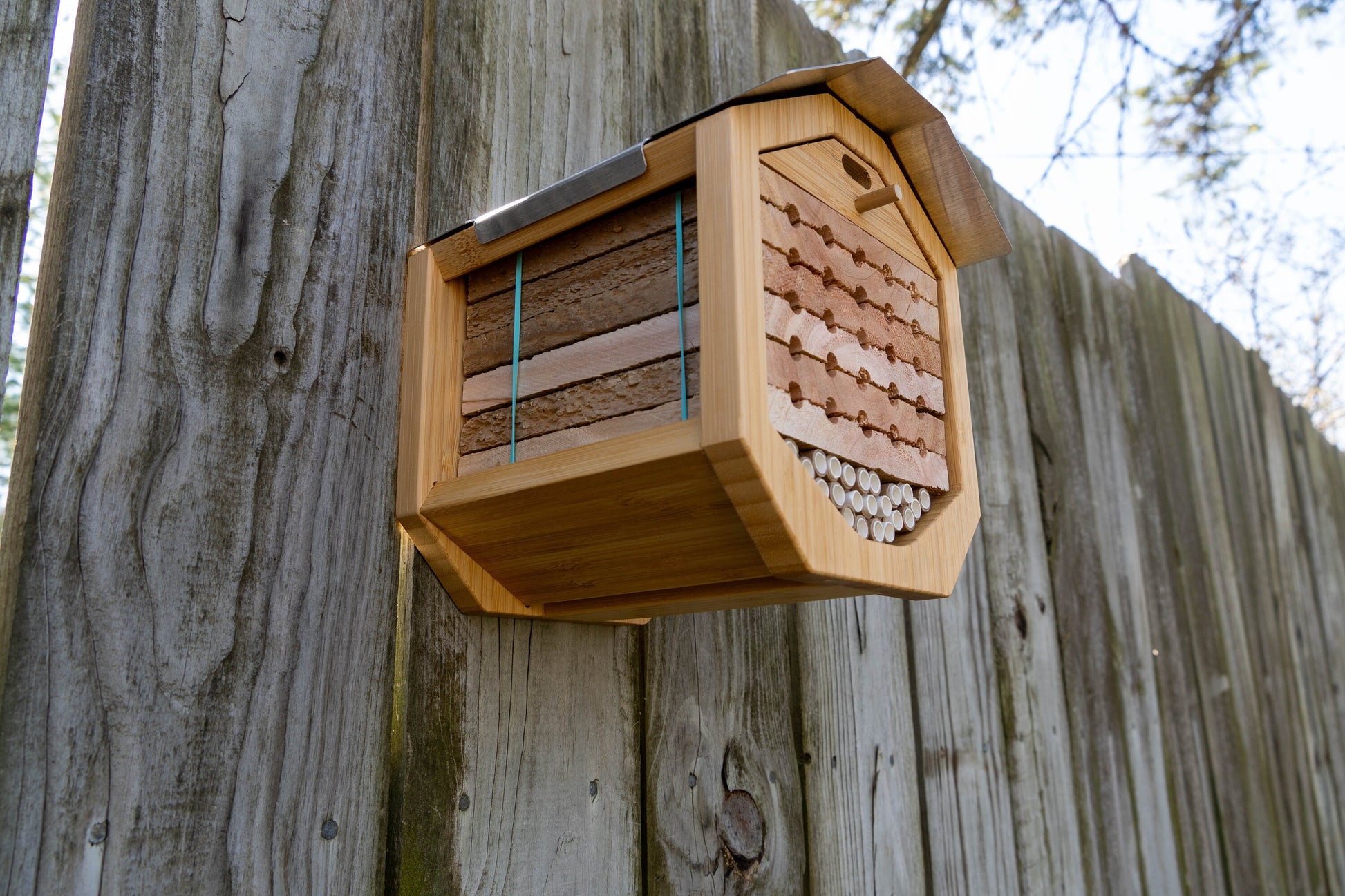 Solitary Bee Condo mounted on a picket fence. looking slightly underneath